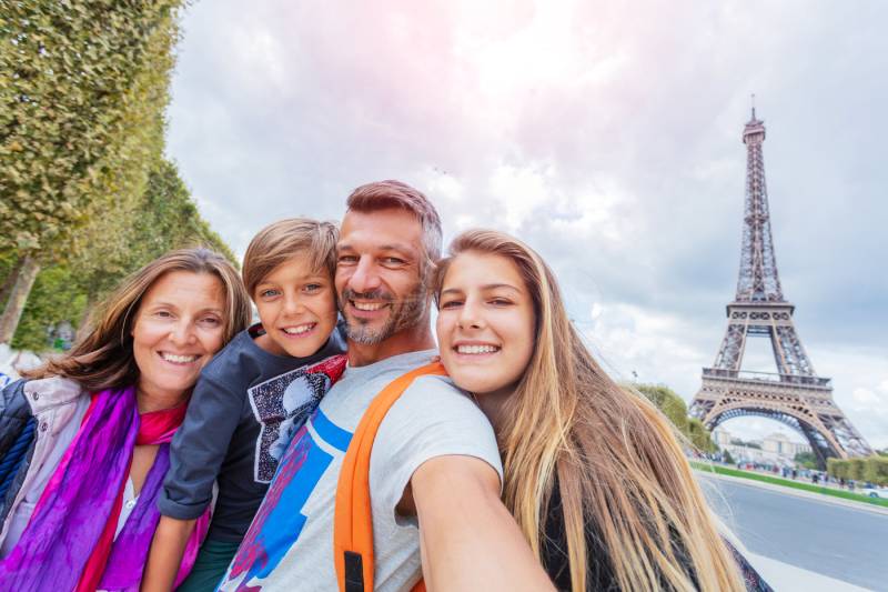 Family picture in front of the Eiffel Tower during a panoramic treasure hunt for families & kids